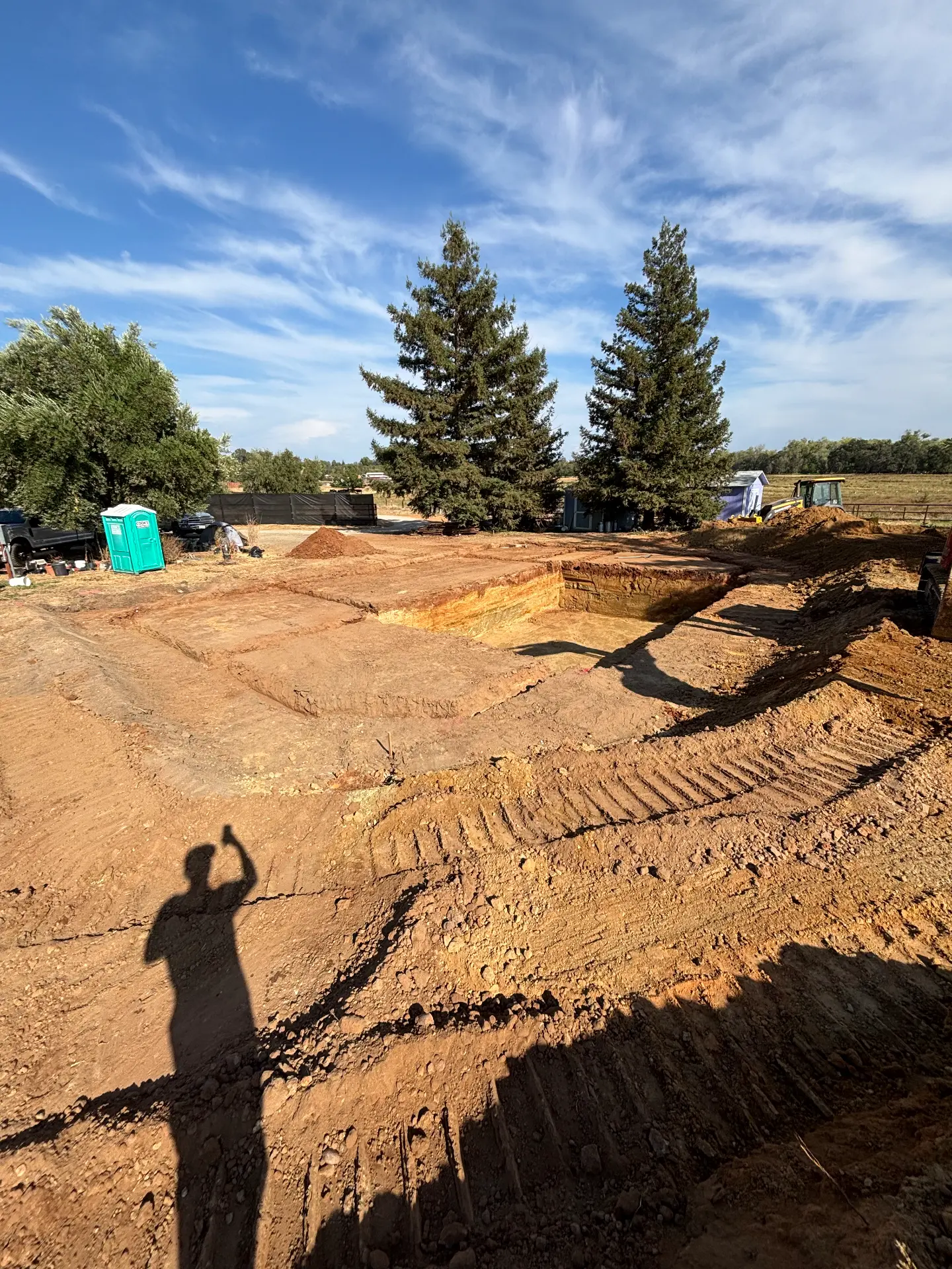 Excavated site with earthmoving equipment and soil stockpiles